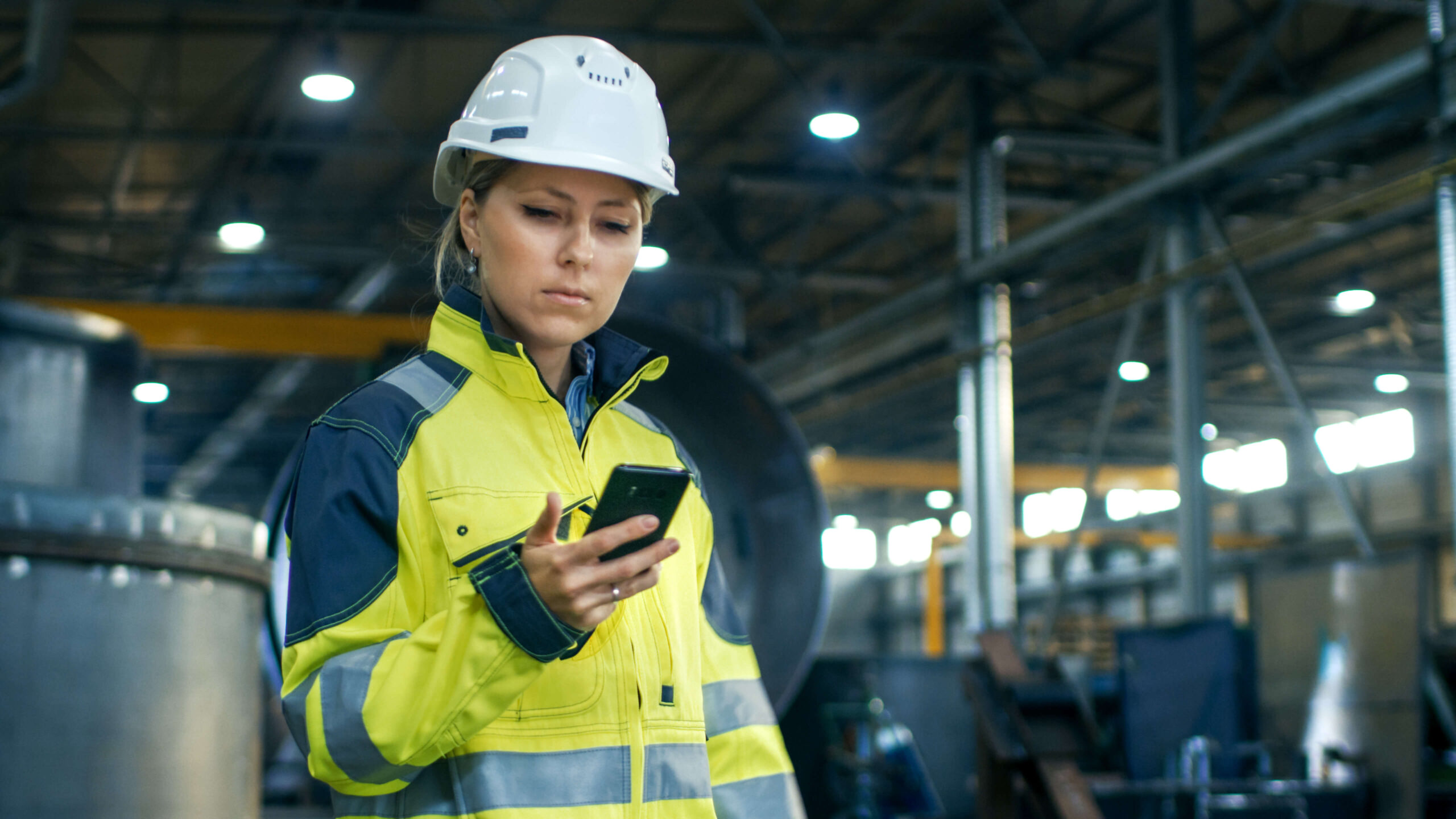 Ouvrier en tenue de travail consultant son téléphone