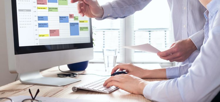 Colleagues planning a meeting with calendar software on computer, search time slot between events, tasks, and appointments, busy business people using time management tool to organize work, office