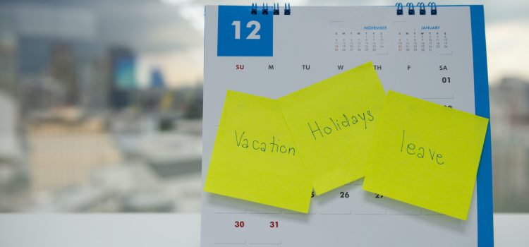 Vacation, holiday and leave on paper note stick on the calendar of December for year end holidays concept
